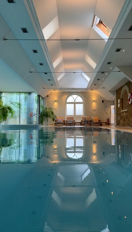 Peaceful indoor swimming pool area with lounge chairs